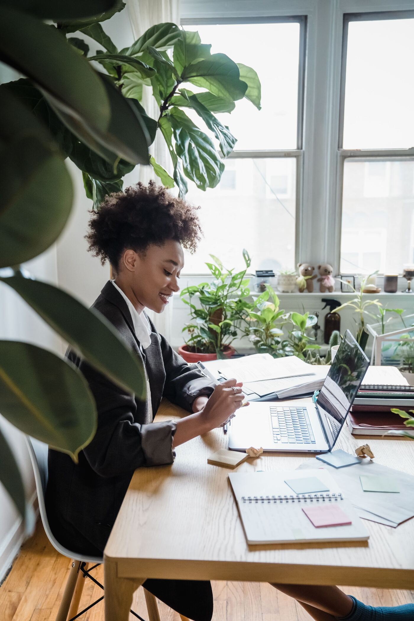Freelance trabajando en un escritorio luminoso con plantas junto a la ventana
